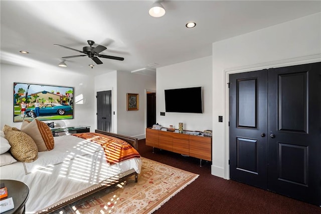 bedroom featuring dark carpet, a closet, and ceiling fan