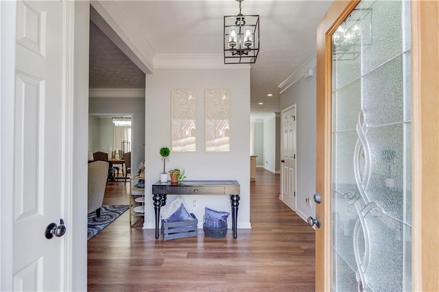 foyer entrance featuring a notable chandelier, baseboards, crown molding, and wood finished floors