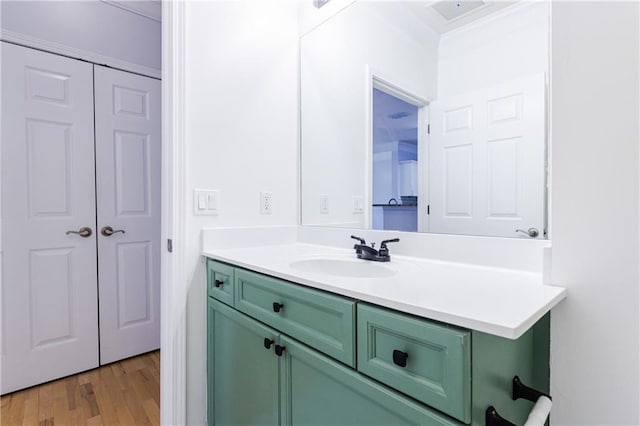 bathroom featuring wood-type flooring, vanity, and ornamental molding