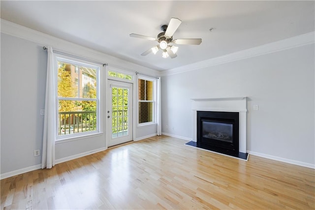 unfurnished living room featuring ceiling fan, ornamental molding, and light hardwood / wood-style flooring