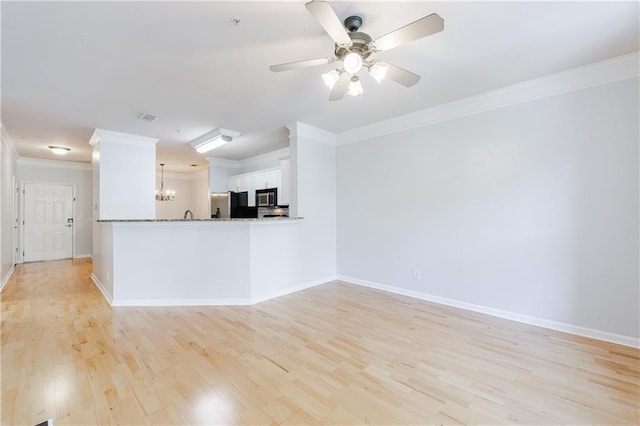 interior space with kitchen peninsula, crown molding, white cabinets, light hardwood / wood-style floors, and fridge