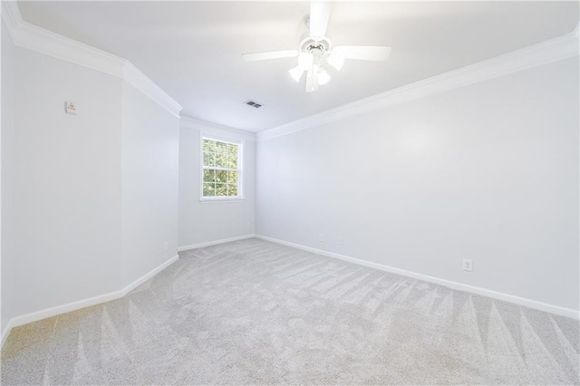 spare room featuring light colored carpet, ceiling fan, and ornamental molding