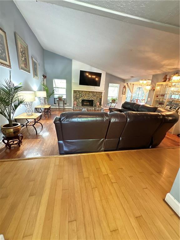 1462 Country Downs Dr, Norcross, GA 30093 - living room featuring lofted ceiling, wood finished floors, and a fireplace