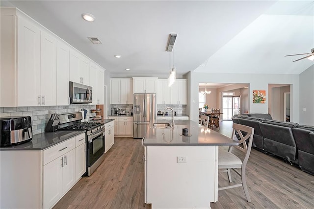 686 Stark St, Lawrenceville, GA 30046 - kitchen featuring appliances with stainless steel finishes, open floor plan, a kitchen bar, dark countertops, and a sink