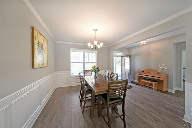 686 Stark St, Lawrenceville, GA 30046 - dining space with a chandelier, crown molding, dark wood-style floors, a wainscoted wall, and a decorative wall