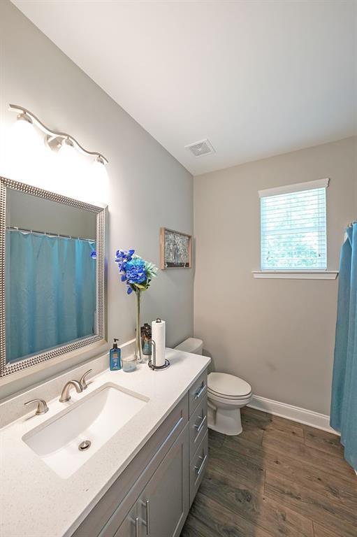 686 Stark St, Lawrenceville, GA 30046 - bathroom featuring vanity, toilet, wood finished floors, and baseboards