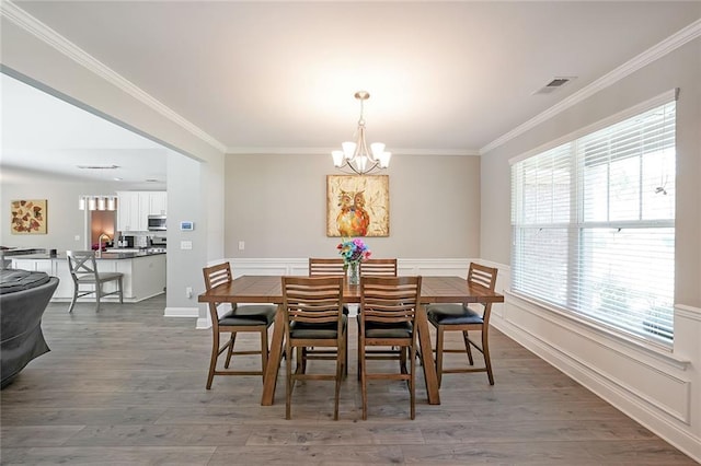 686 Stark St, Lawrenceville, GA 30046 - dining space with a chandelier, crown molding, wood finished floors, and baseboards