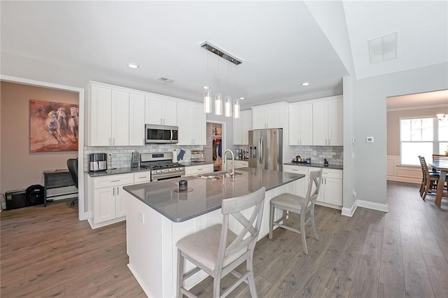 686 Stark St, Lawrenceville, GA 30046 - kitchen featuring stainless steel appliances, a sink, dark countertops, tasteful backsplash, and a kitchen breakfast bar