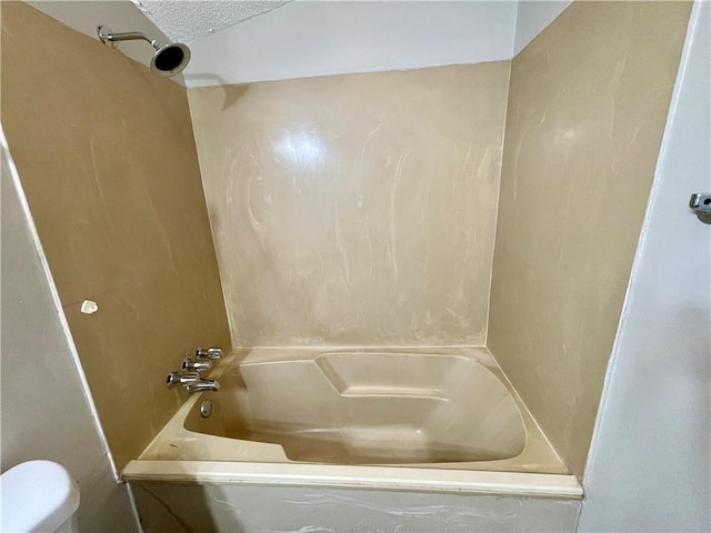 bathroom featuring shower / tub combination, toilet, and a textured ceiling