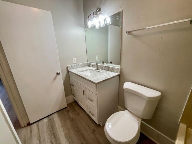 bathroom featuring vanity, toilet, and hardwood / wood-style floors