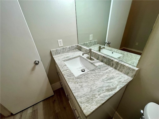 bathroom with vanity, hardwood / wood-style flooring, and toilet