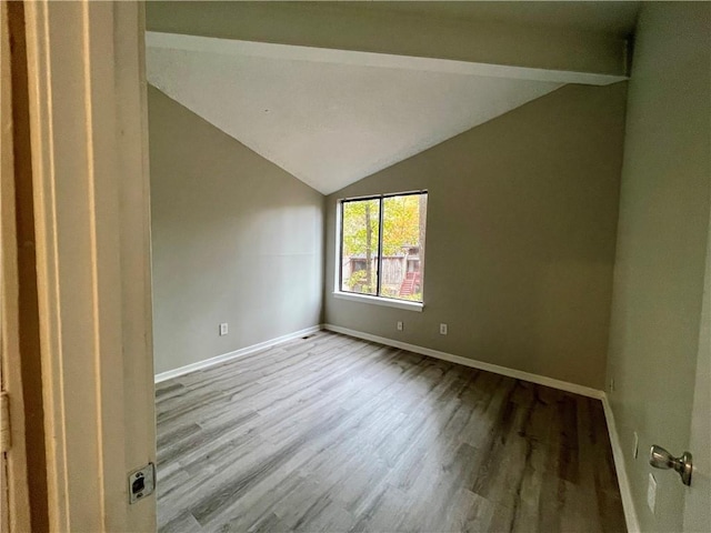 spare room featuring vaulted ceiling and light hardwood / wood-style flooring