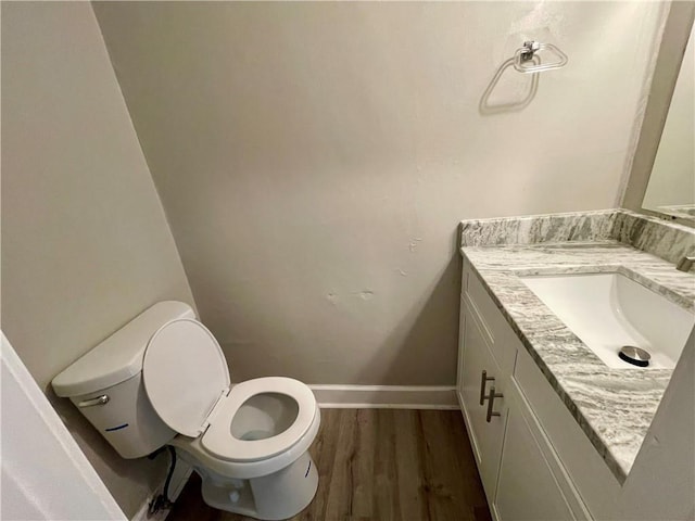 bathroom featuring vanity, wood-type flooring, and toilet