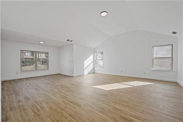 unfurnished living room with light wood-type flooring and lofted ceiling