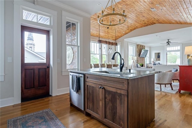 kitchen featuring a kitchen island with sink, a sink, open floor plan, hanging light fixtures, and dishwasher