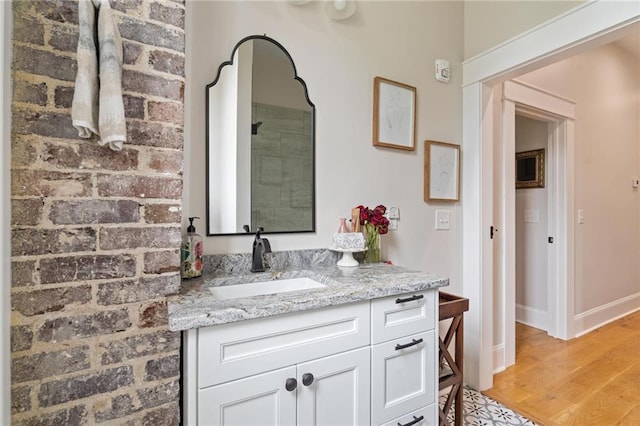 bathroom with vanity, baseboards, and wood finished floors