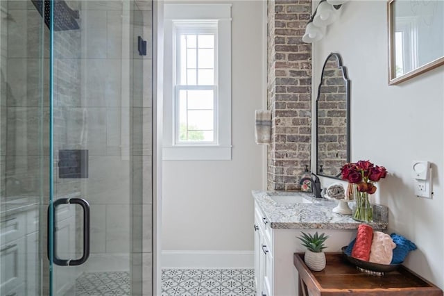 full bath featuring baseboards, tiled shower, and vanity