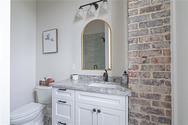 bathroom featuring toilet, a stall shower, and vanity