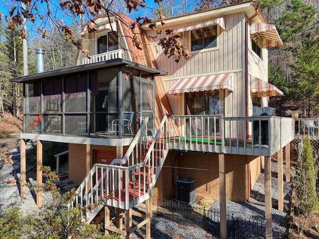 rear view of house featuring a sunroom and central air condition unit