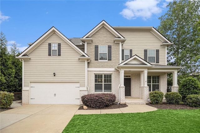 craftsman inspired home with an attached garage, brick siding, a front yard, concrete driveway, and covered porch