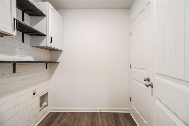 laundry room featuring baseboards, cabinet space, and dark wood-style flooring