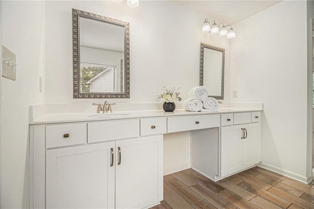 bathroom with double vanity, a sink, and wood finished floors
