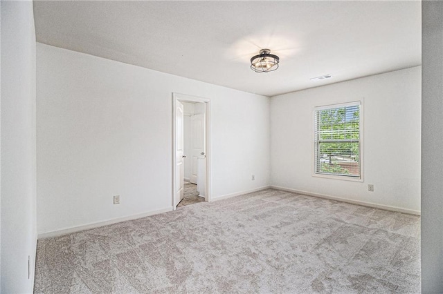 empty room with carpet flooring, baseboards, and visible vents