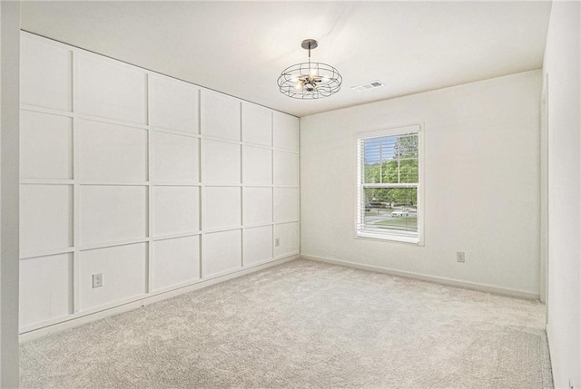 unfurnished room with an inviting chandelier, baseboards, carpet, and visible vents
