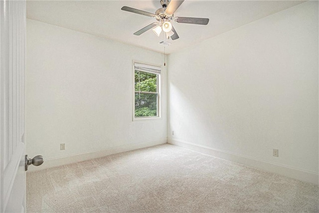 carpeted empty room featuring baseboards, a ceiling fan, and visible vents