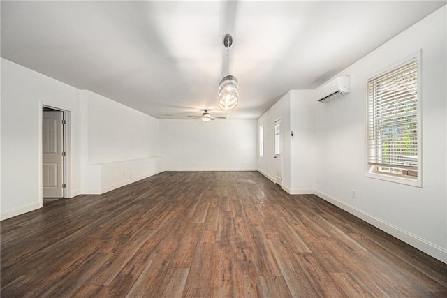 interior space featuring a ceiling fan, baseboards, dark wood finished floors, and a wall mounted air conditioner