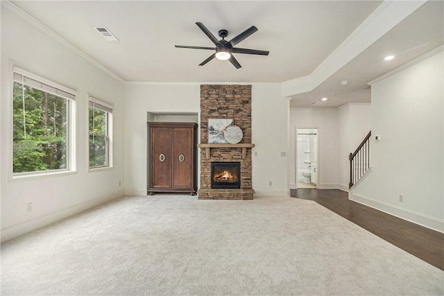 unfurnished living room featuring crown molding, ceiling fan, stairway, and visible vents