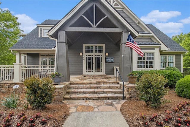 view of front of home featuring a porch, french doors, and roof with shingles