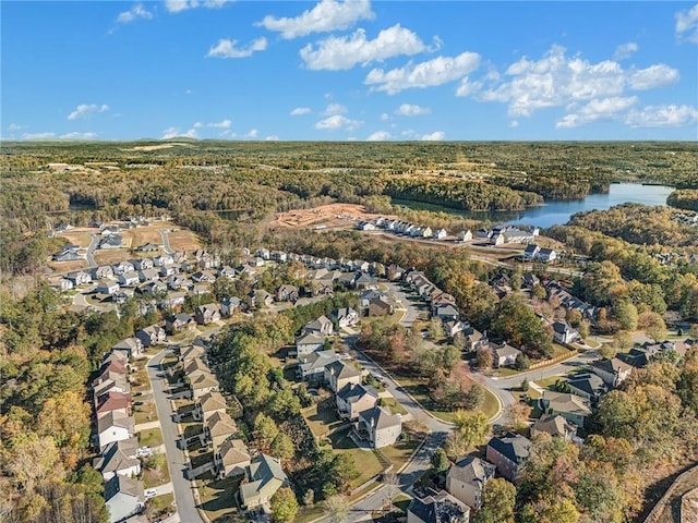 birds eye view of property with a forest view, a water view, and a residential view