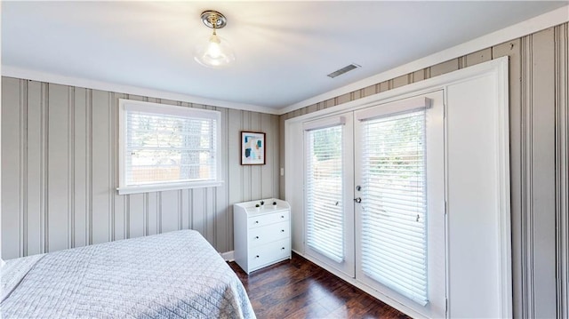 bedroom featuring access to outside, multiple windows, and dark hardwood / wood-style flooring