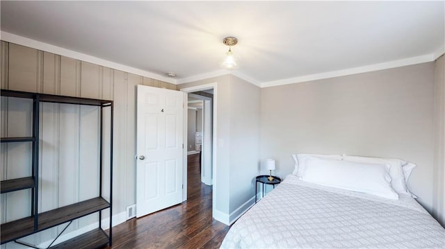 bedroom featuring ornamental molding and dark hardwood / wood-style flooring