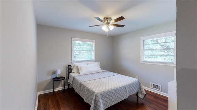 bedroom with dark hardwood / wood-style flooring and ceiling fan