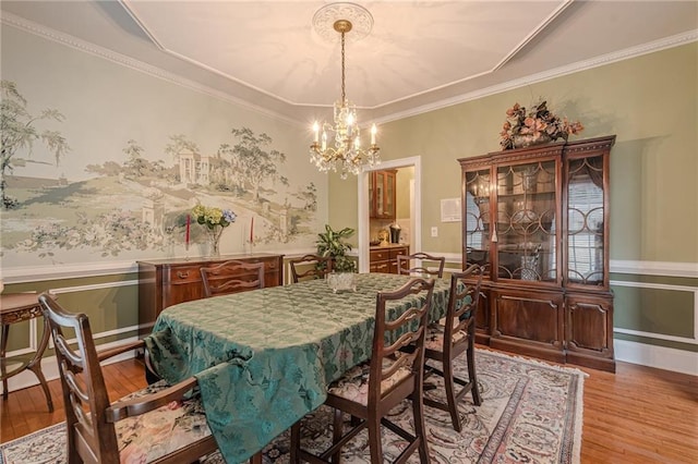 dining area with crown molding, a notable chandelier, wood finished floors, and baseboards