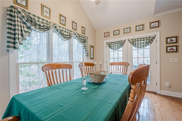 dining space with baseboards, lofted ceiling, and wood finished floors