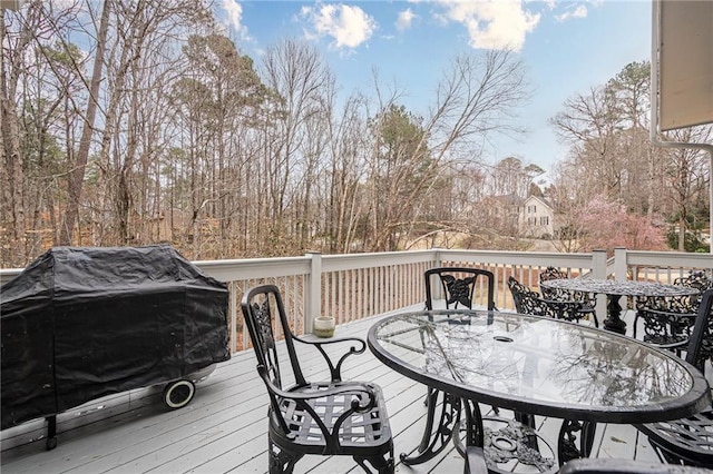 wooden terrace with outdoor dining space and a grill