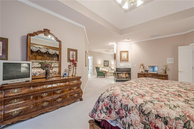 carpeted bedroom featuring visible vents, a glass covered fireplace, and crown molding