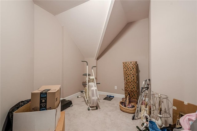 exercise room with baseboards, carpet, and vaulted ceiling