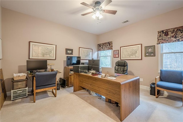 office with visible vents, light colored carpet, baseboards, and ceiling fan