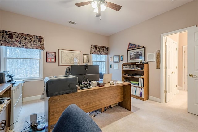 office area featuring light colored carpet, baseboards, visible vents, and ceiling fan