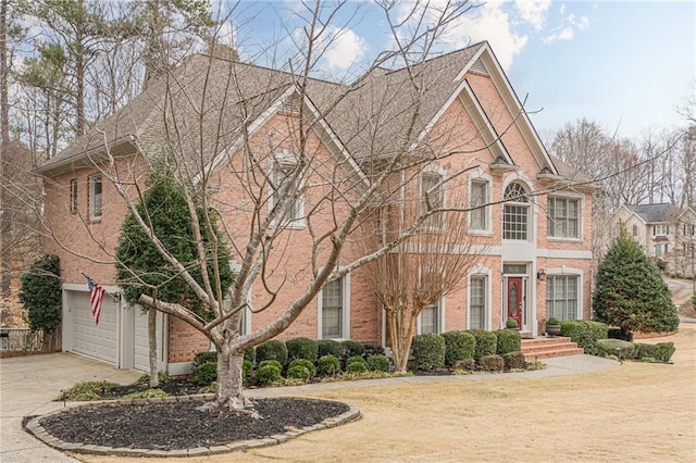 view of front of house with a garage, brick siding, and driveway