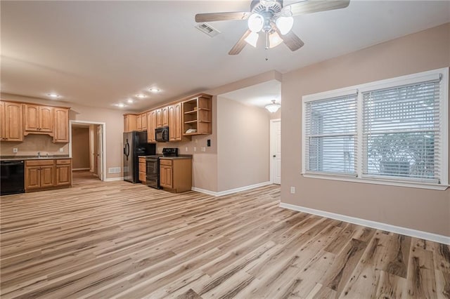 kitchen with visible vents, black appliances, open shelves, a sink, and light wood-style floors