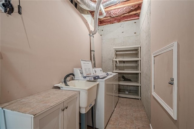 laundry area featuring cabinet space, light tile patterned floors, and separate washer and dryer