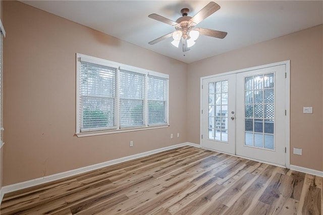 interior space featuring ceiling fan, french doors, baseboards, and wood finished floors