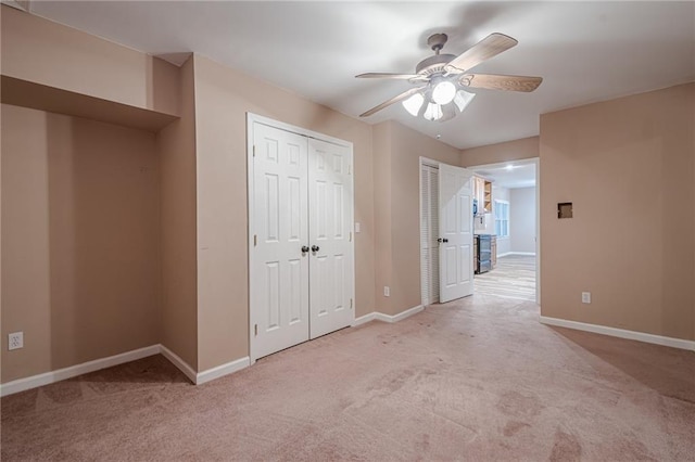 unfurnished bedroom featuring carpet flooring, a ceiling fan, and baseboards