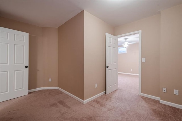 unfurnished bedroom featuring baseboards and light carpet