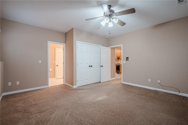 unfurnished bedroom featuring a ceiling fan, baseboards, visible vents, a closet, and light carpet